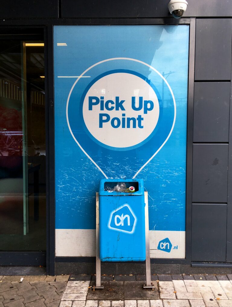 de poster van de Albert Hein om aan te geven dat er een pick up point is wijst direct naar de prullenmand