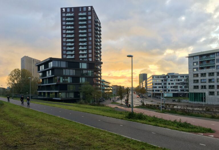 Weg loopt direct richting de zonsopgang met links en rechts flatgebouwen