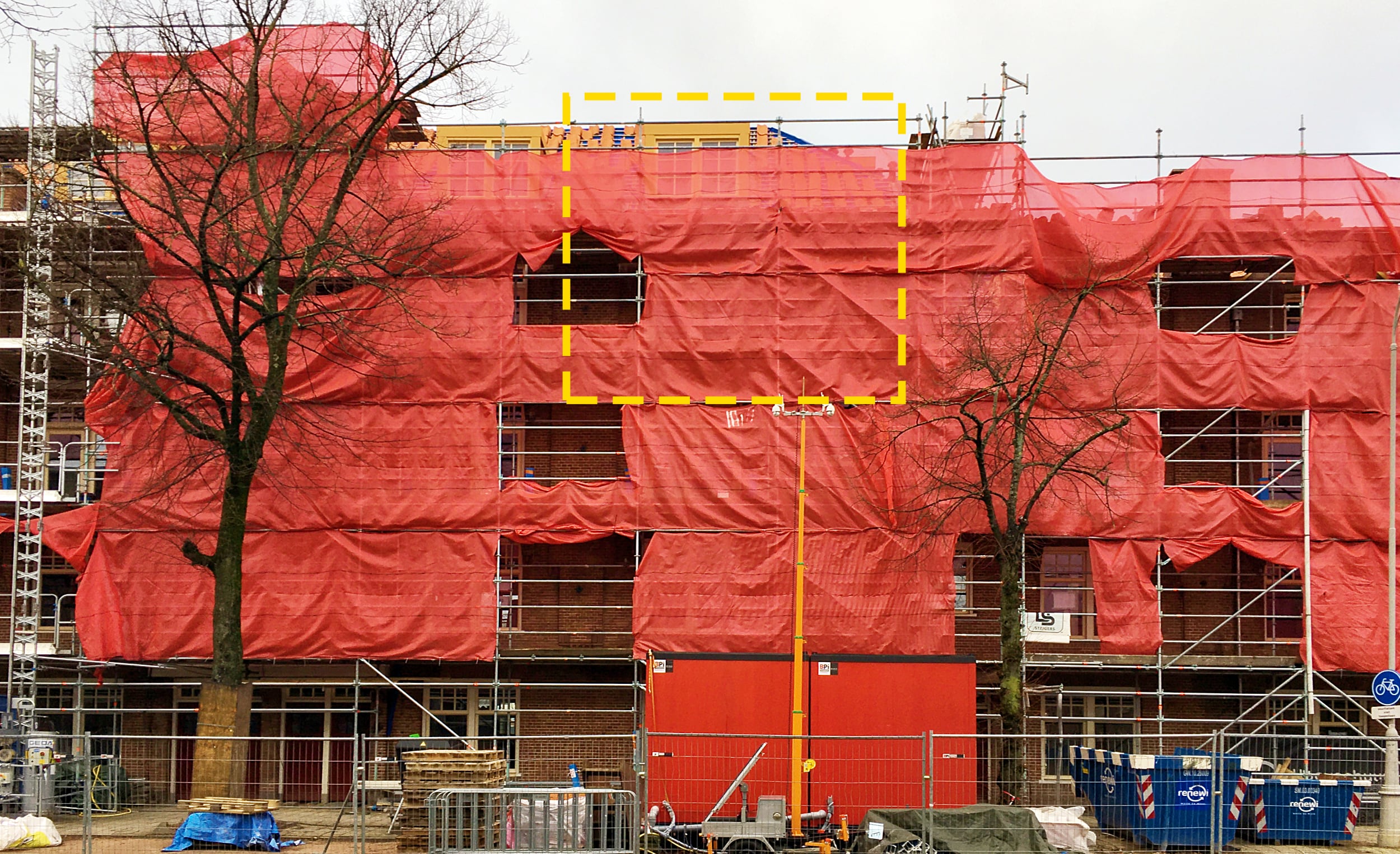 Foto van gebouw zeeburgerdijk Amsterdam in de bouwstijgers met met op veel plekken rood doek ervoor