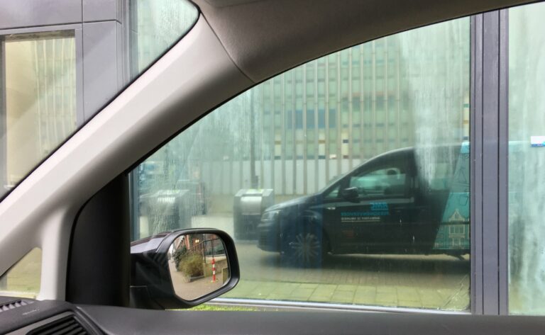 Spiegeling van de Caddy in een deels beslagen raam met een silhouet van mij achter het stuur.
