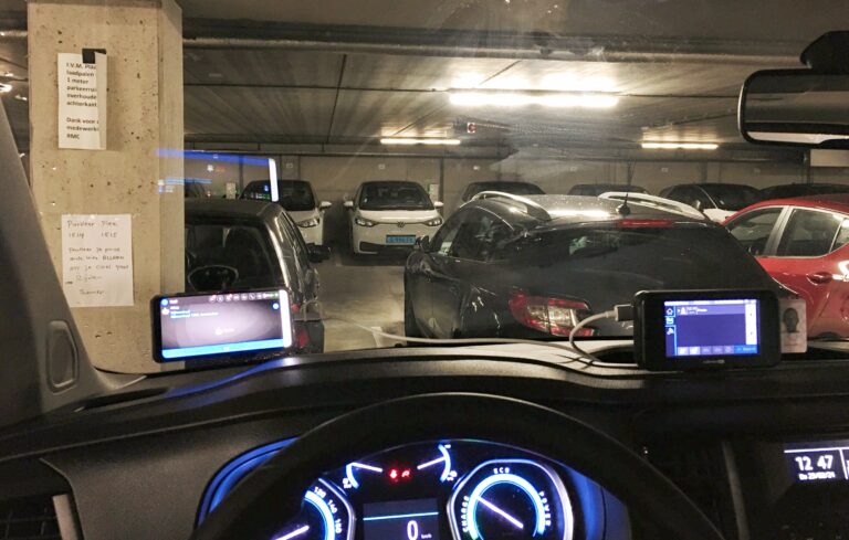 Uitzicht vanuit mijn voorruit van de auto. Deze keer in een betonnen parkeergarage, samen met verschillende auto's.