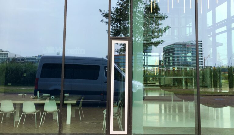 de spiegeling van de auto in de ramen van een gebouw.