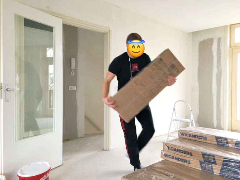zoon draagt pakketten met kurkvloer de nog niet geschilderde kamer in