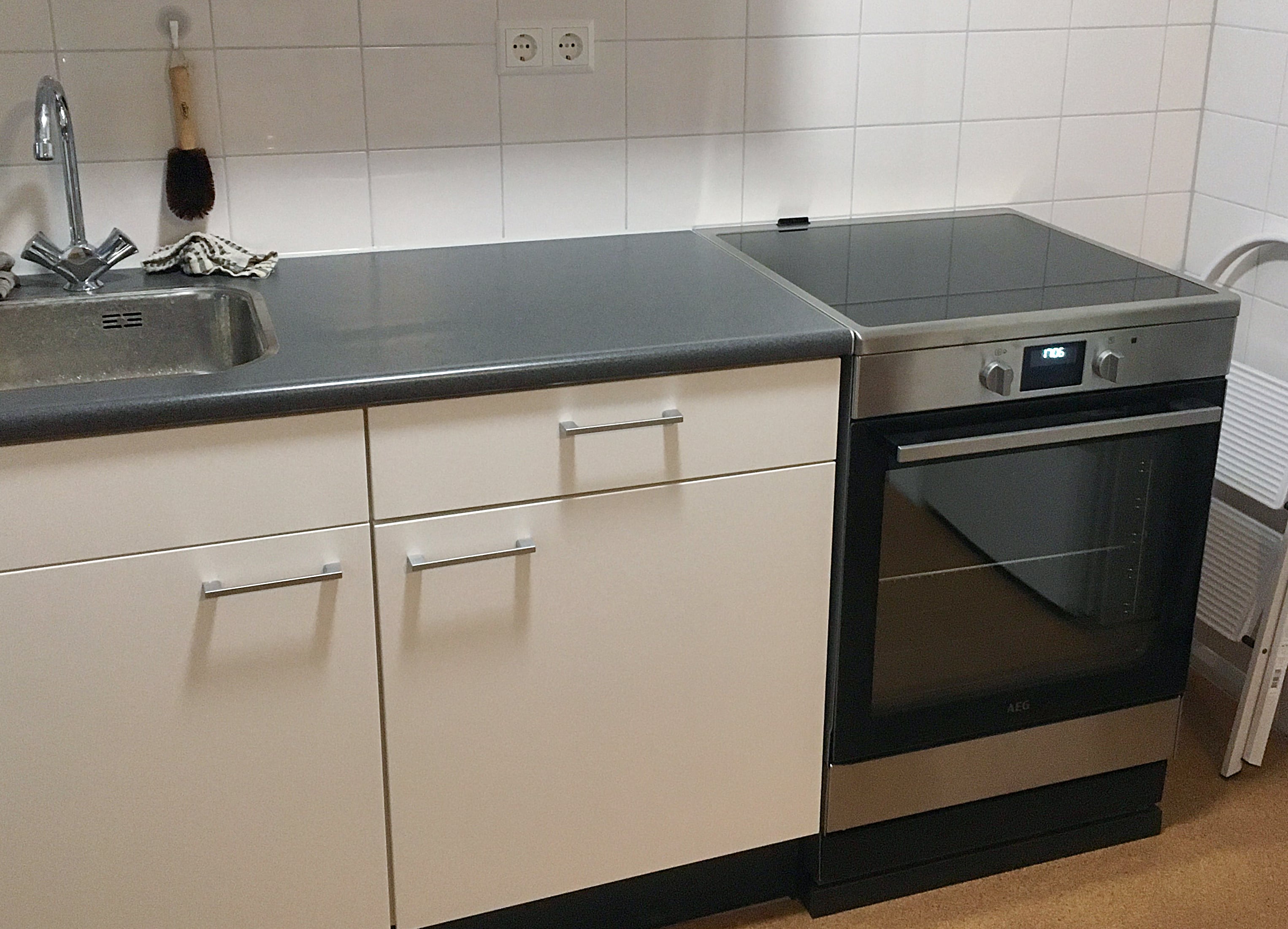 Witte keuken met rechts een inductiefornuis in RVS