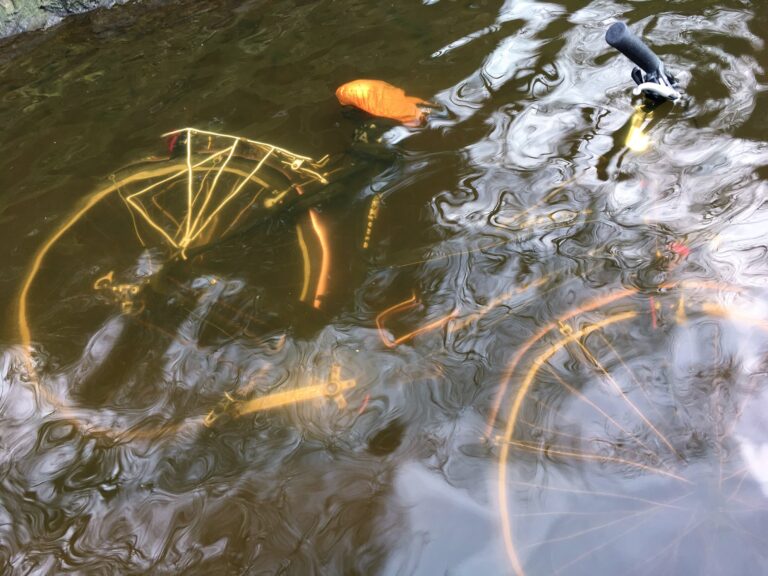 liggende fiets net onder water met het handvat er bovenuit. Het is een mooie nette fiets.