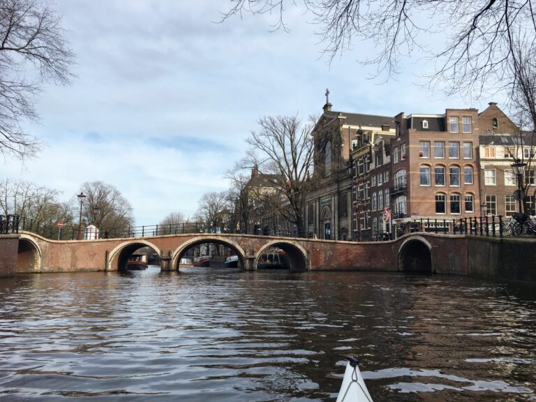 Water kruispunt op de Prinsengracht in Amsterdam met stenen bruggen met de karakteristieke bogen. 