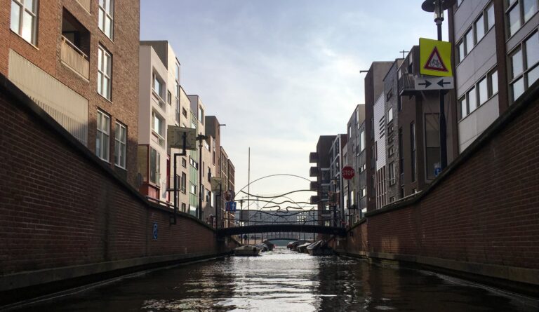 Een klein grachtje met een bruggetje en wat kleine bootjes aan de kade. Met links en rechts moderne huizen van ongeveer 5 verdiepingen. Het voelt bijna als een tunnel. Er zijn geen bomen. Slechts steen, beton en staal.