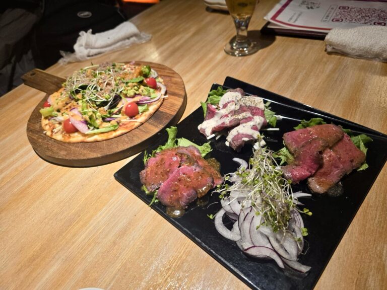 Het eten. Links een groente pizza. rechts een mooie uitstalling van vleesgerechten.