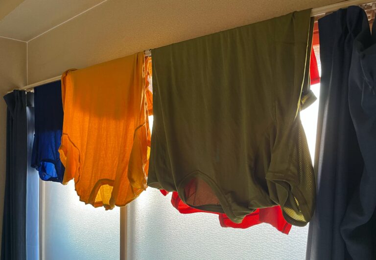 kleurige t-shirts opgehangen aan de gordijnrails om te drogen