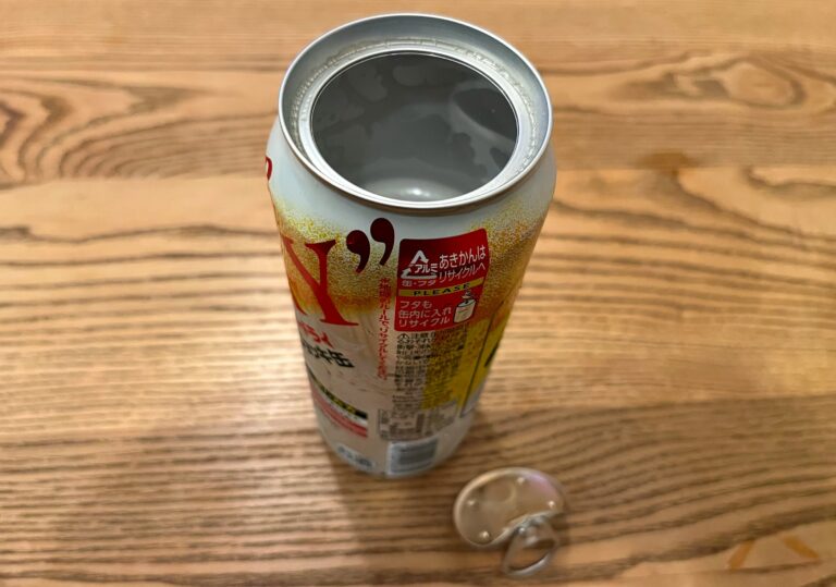 Leeg blikje van boven op een houten tafel waar de hele bovenkant vanaf is in plaats van maar een klein gleufje