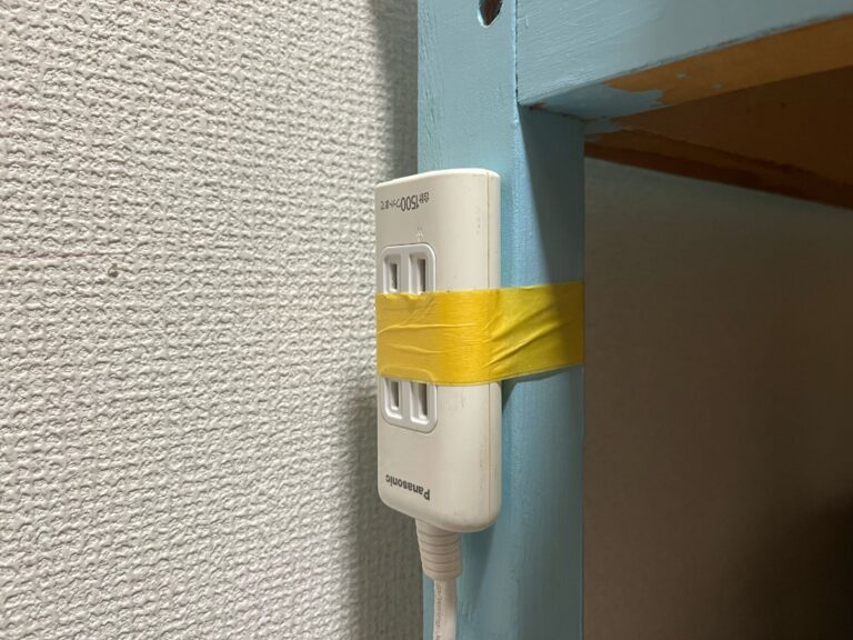 Stekkerdoosje aan een half geschilderde tafelpoot geplakt met wat tape