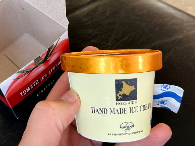 Bakje schepijs met een gouden dekseltje in tomatensmaak